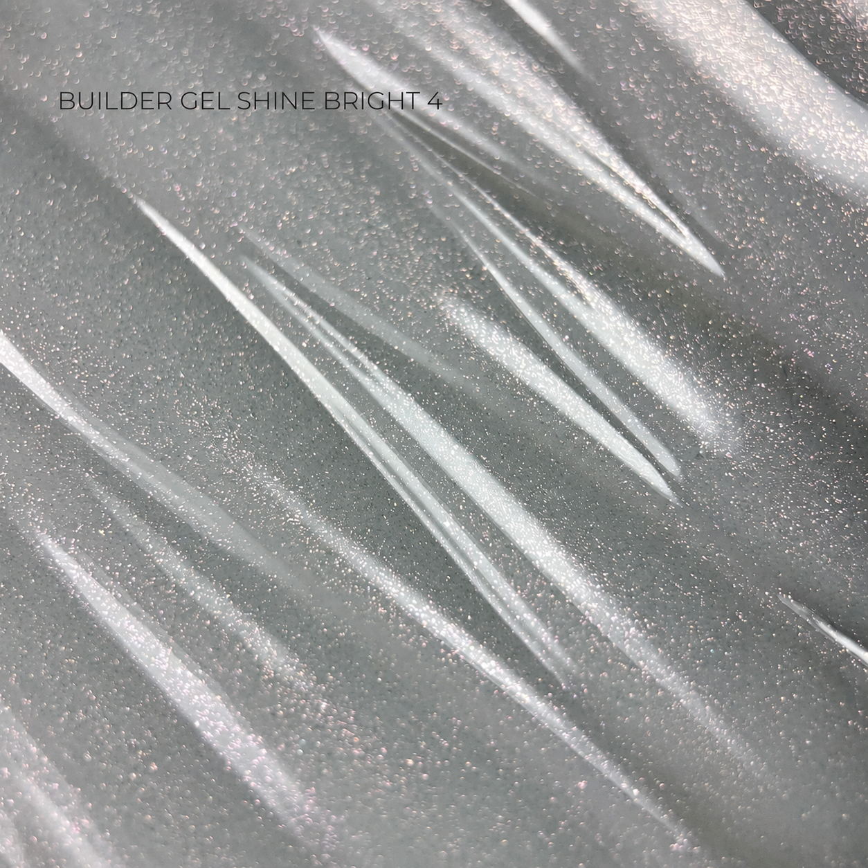 A close-up texture shot of a silver-gray builder gel polish with fine glitter and a glossy finish, featuring diagonal light reflections and the text 'BUILDER GEL SHINE BRIGHT 4' in the upper left.