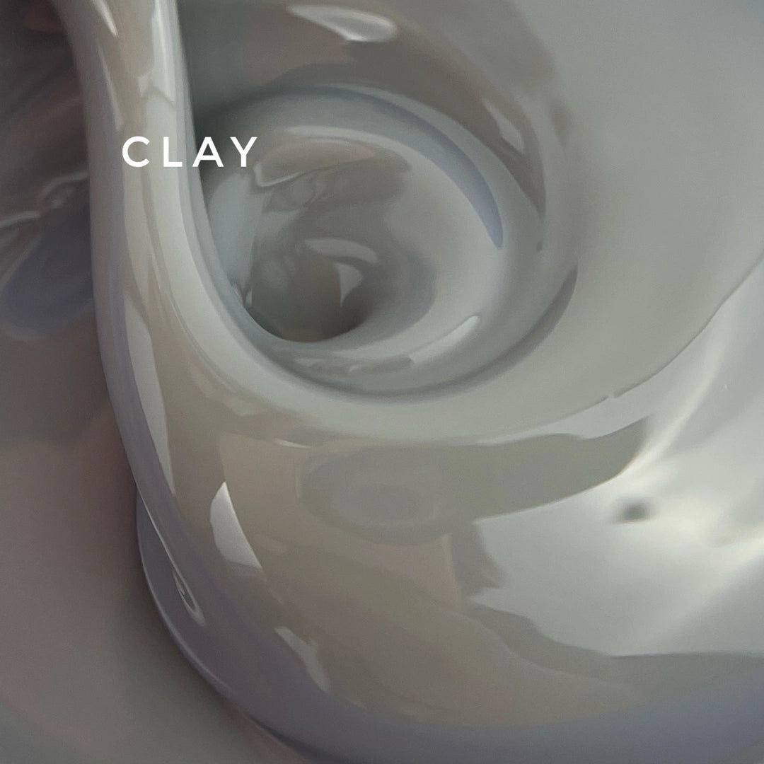 Close-up of a clay sculpture with swirling patterns and the word 'CLAY' above it.